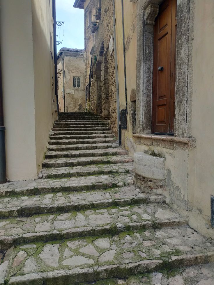 A typical staircase in a historic village, surrounded by plants and nature.