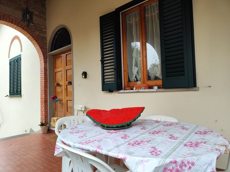 A calm veranda featuring a spacious table adorned with a watermelon-themed centerpiece.