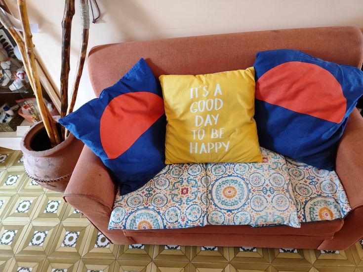 A cozy sofa with colorful cushions and an inspiring message on the wall.