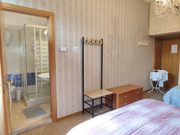 Spacious room with private bathroom and simple decor, perfect for a comfortable stay.