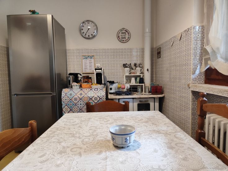 A cozy kitchen with a refrigerator and a table, perfect for spending time together.