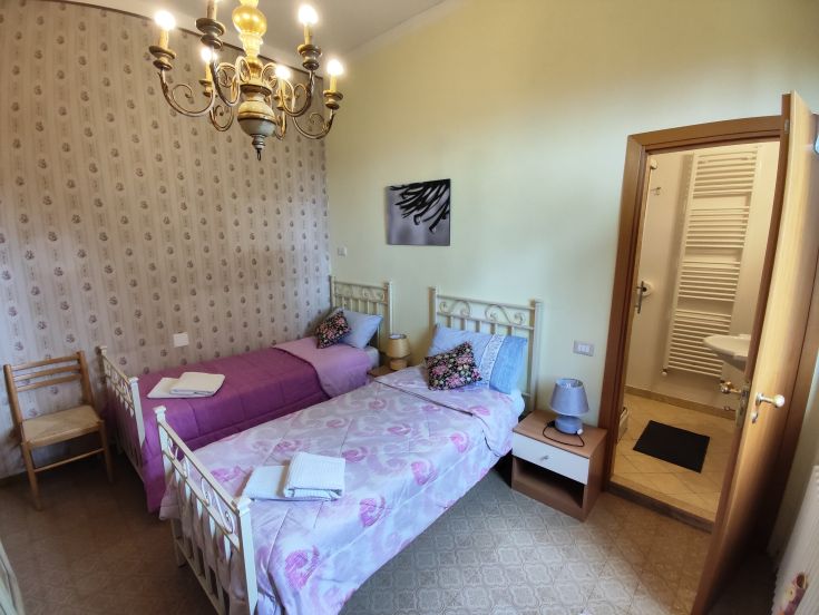 Cozy space with single beds and an en-suite bathroom, perfect for relaxation moments.