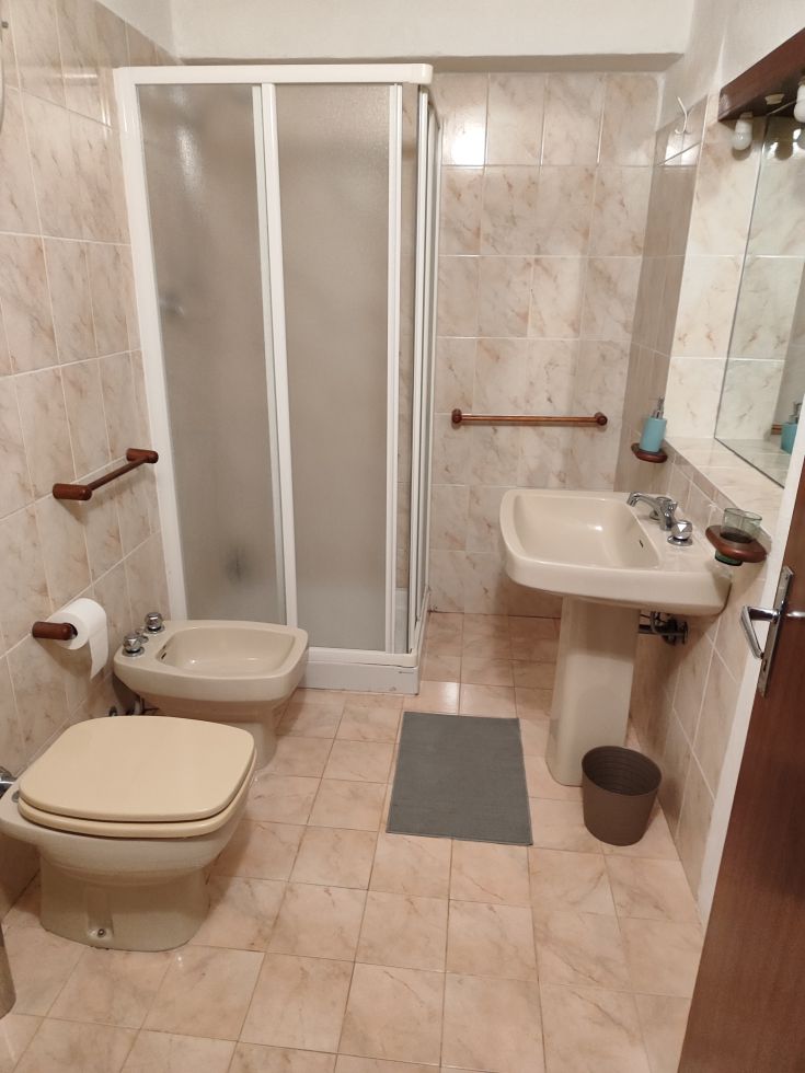 Bathroom furnished with shower, sink, and toilet. Practical and functional style.