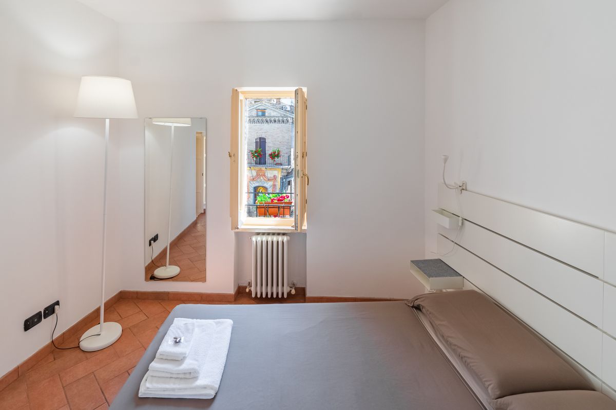 Spacious room with a double bed, bright view, and a panorama of the Umbrian landscape.