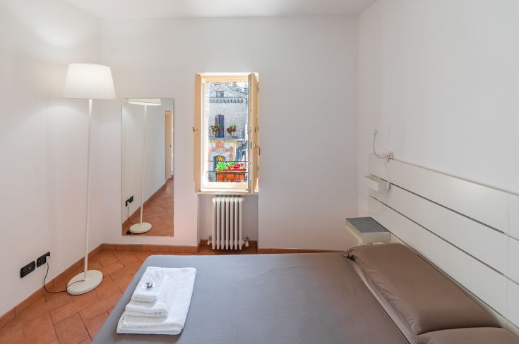 Geräumiges Zimmer mit Doppelbett, hellem Ausblick und Panorama auf die umbrische Landschaft.