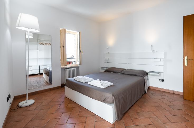 Modernes Apartment mit Doppelbett und Blick auf die Basilika von Assisi.