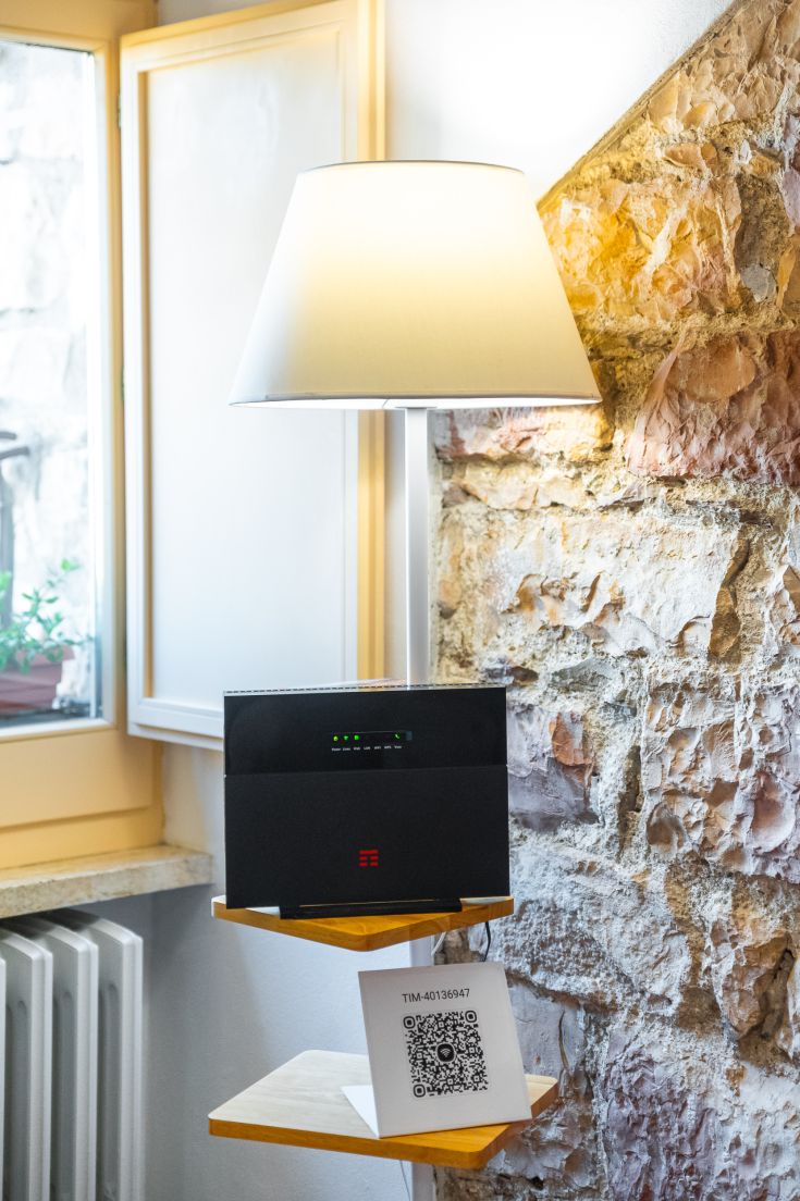 Ein moderner Router neben einer Lampe in einem Raum mit Steinwänden.