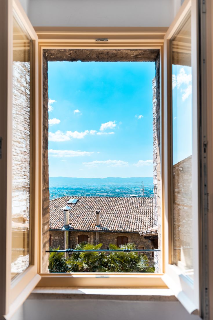 Blick vom Appartement Frate Elia in Umbrien, mit blauem Himmel und typischen Steindächern.