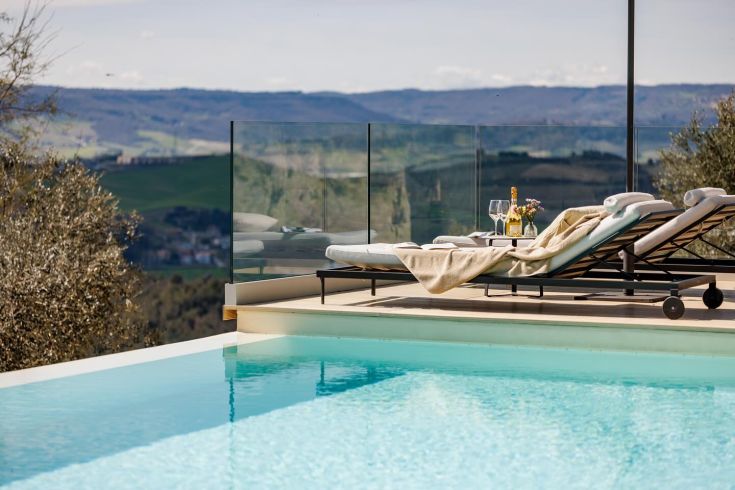 Une zone de détente avec une piscine entourée de collines verdoyantes, idéale pour profiter de la nature.
