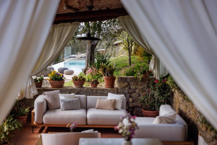 Un coin de détente avec vue sur une piscine, entouré de plantes et de fleurs colorées.