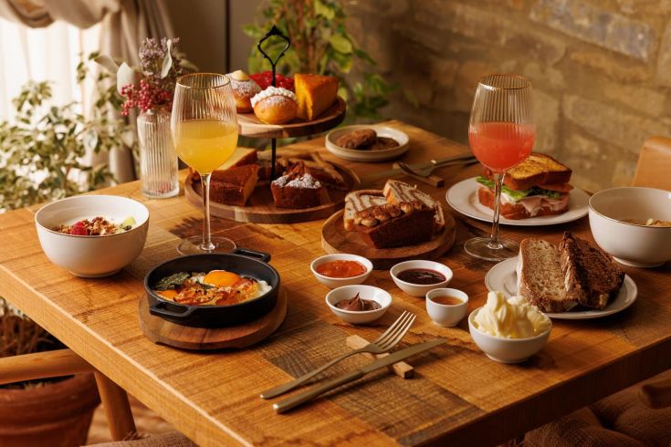 Un brunch copieux servi sur une table en bois, avec divers plats et boissons colorées.
