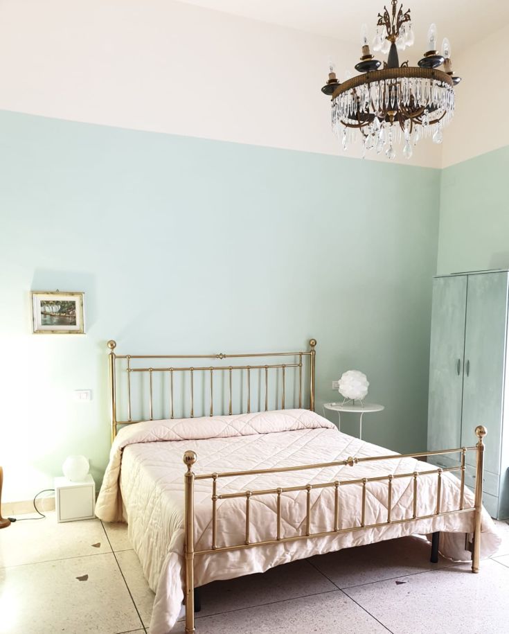 Spazio interno semplice con letti in ferro battuto e decorazioni contemporanee. Ambiente luminoso e accogliente.