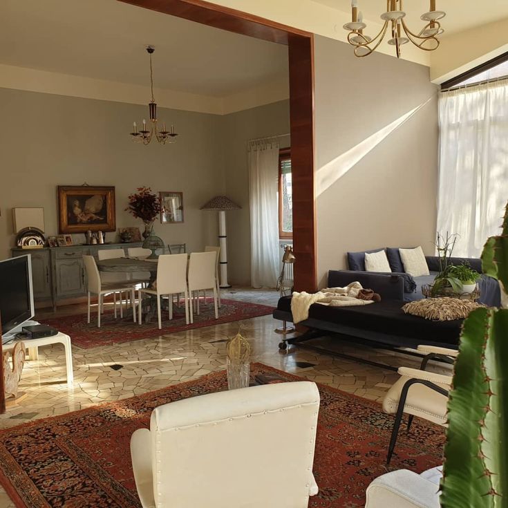 Un soggiorno ben illuminato e confortevole, con arredi funzionali e dettagli decorativi semplici.