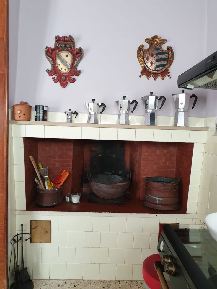 Un'area della cucina con una caffettiera in alluminio e decorazioni in legno. Ambiente semplice e accogliente.