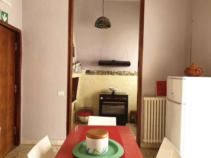 Cucina luminosa con tonalità vivaci, caratterizzata da elementi decorativi semplici e un'atmosfera calda.