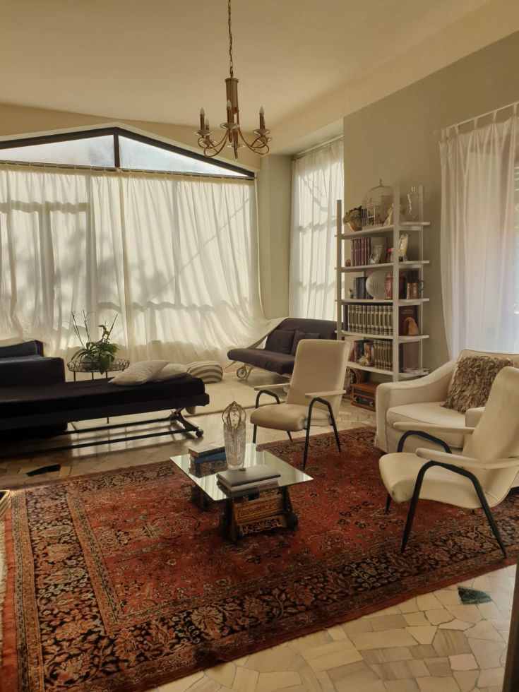 Un soggiorno luminoso con mobili sobri e dettagli semplici, creando un'atmosfera accogliente.