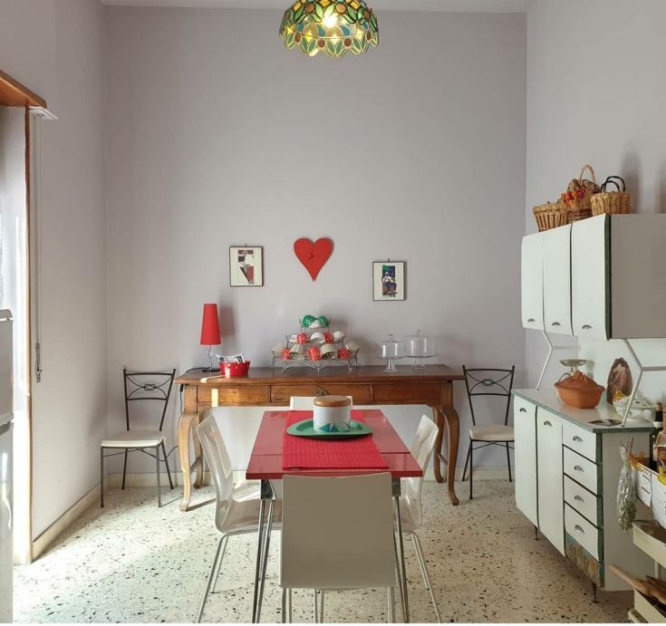 Una cucina semplice e funzionale, con un tavolo al centro e alcune decorazioni colorate.