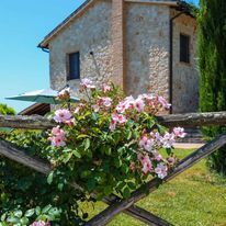 Un charmant mas en pierre avec des fleurs, niché au vert de l'Ombrie, parfait pour une escapade relaxante.