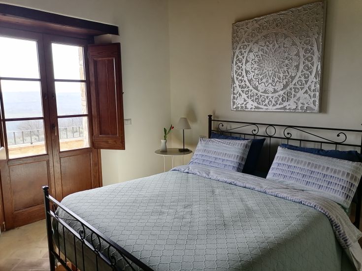 Chambre spacieuse avec une vue relaxante, équipée de meubles simples et fonctionnels, idéale pour des moments de tranquillité.