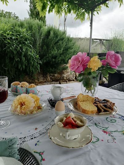 Une table en plein air décorée de fleurs et d'un déjeuner léger, baignant au soleil.