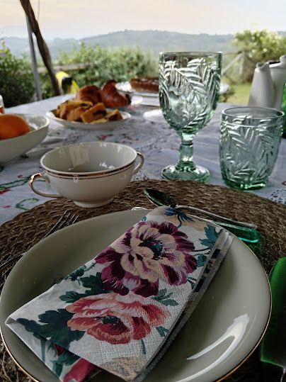 Une table bien dressée avec une vue sur des collines vertes.