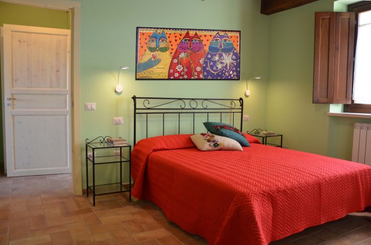 Camera ben illuminata con letto matrimoniale e arredo semplice. Spazio accogliente per un soggiorno tranquillo.