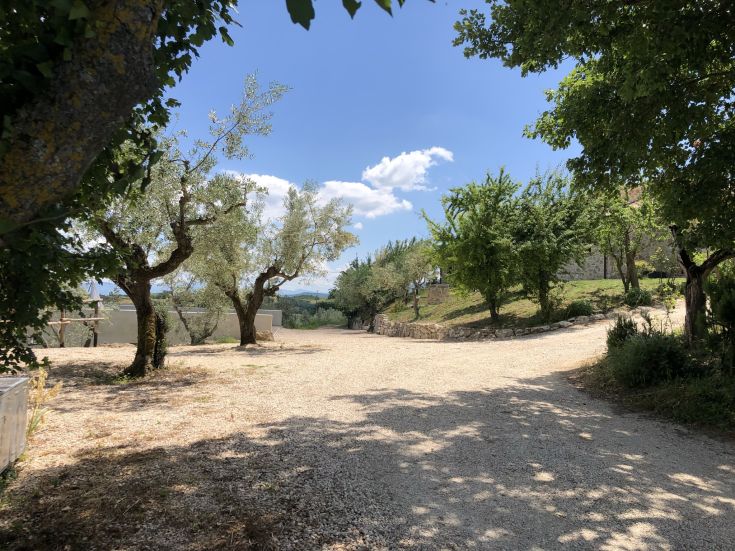 Struttura agrituristica circondata dalla natura, con giardino e piscina che si affaccia su colline e vigneti.