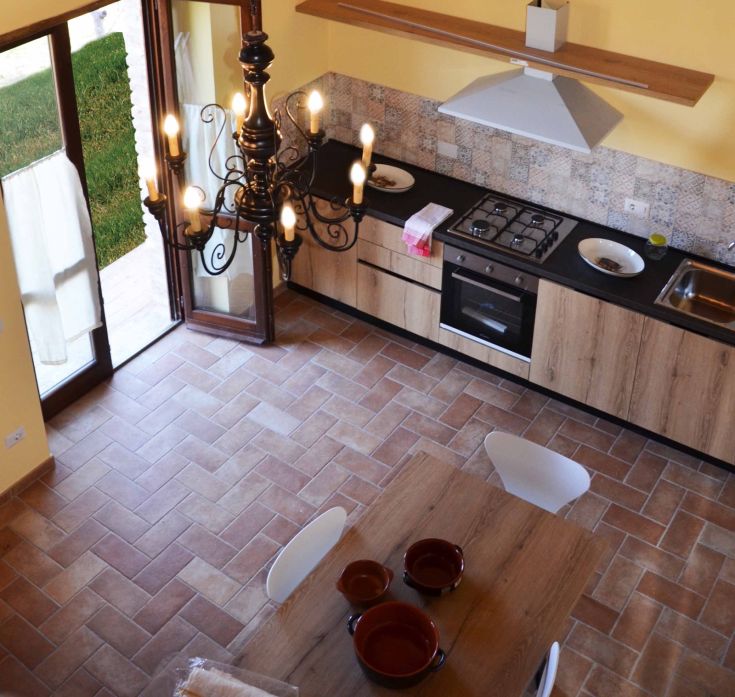 Cucina moderna e accogliente, situata in un agriturismo, con affaccio su un giardino curato. Ideale per pasti in compagnia.