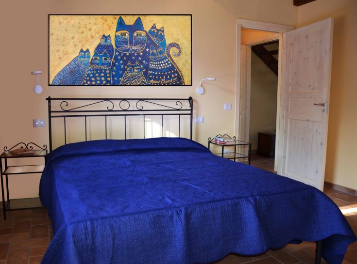 Ambiente confortevole con biancheria blu, adatto per il relax e il riposo.