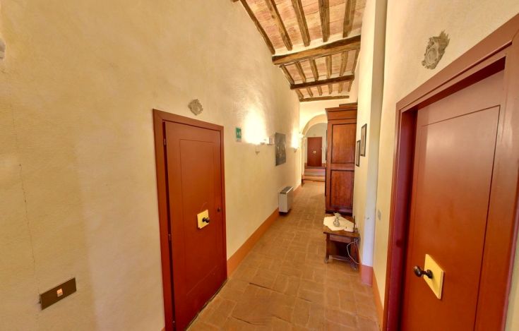 A historic monastery corridor with classic wooden doors and furniture.