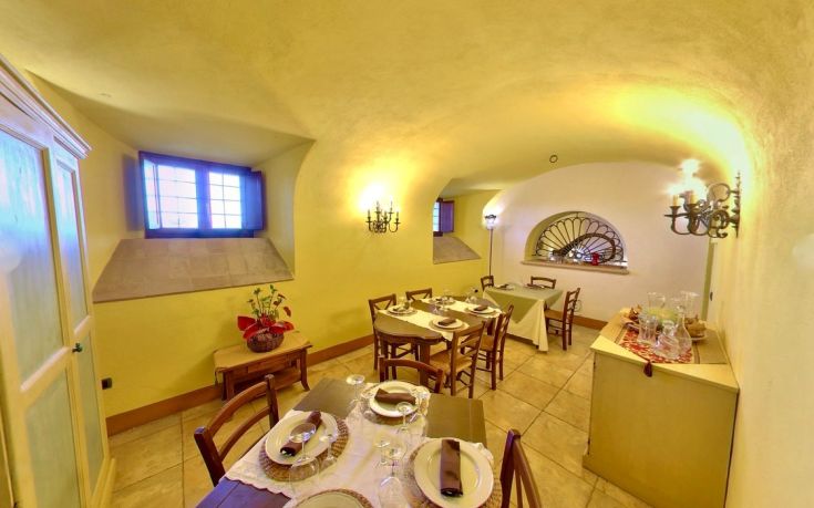 Casual restaurant located in an old monastery, with tables arranged to accommodate visitors.