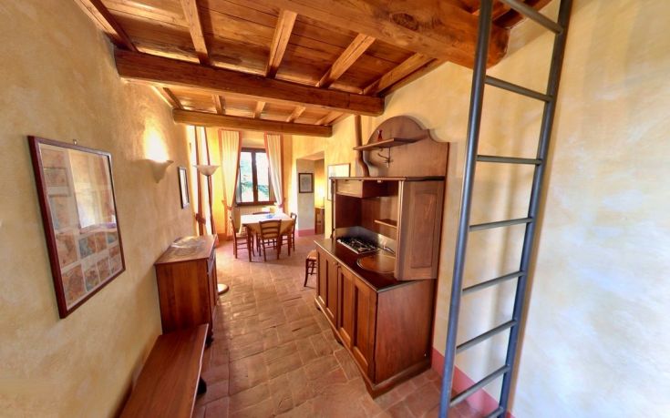 Cozy interior of a country house featuring a simple kitchen and wooden furniture, creating a warm and inviting atmosphere.