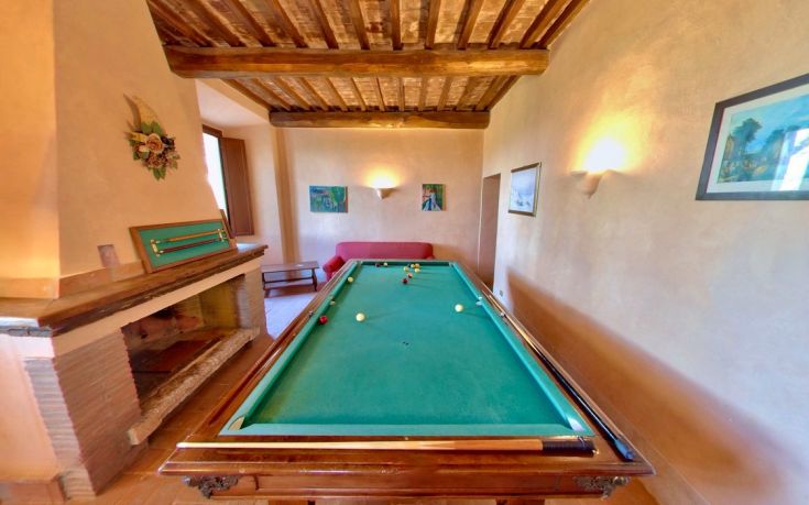 A cozy room featuring a billiard table and a fireplace, perfect for leisure and relaxation moments.