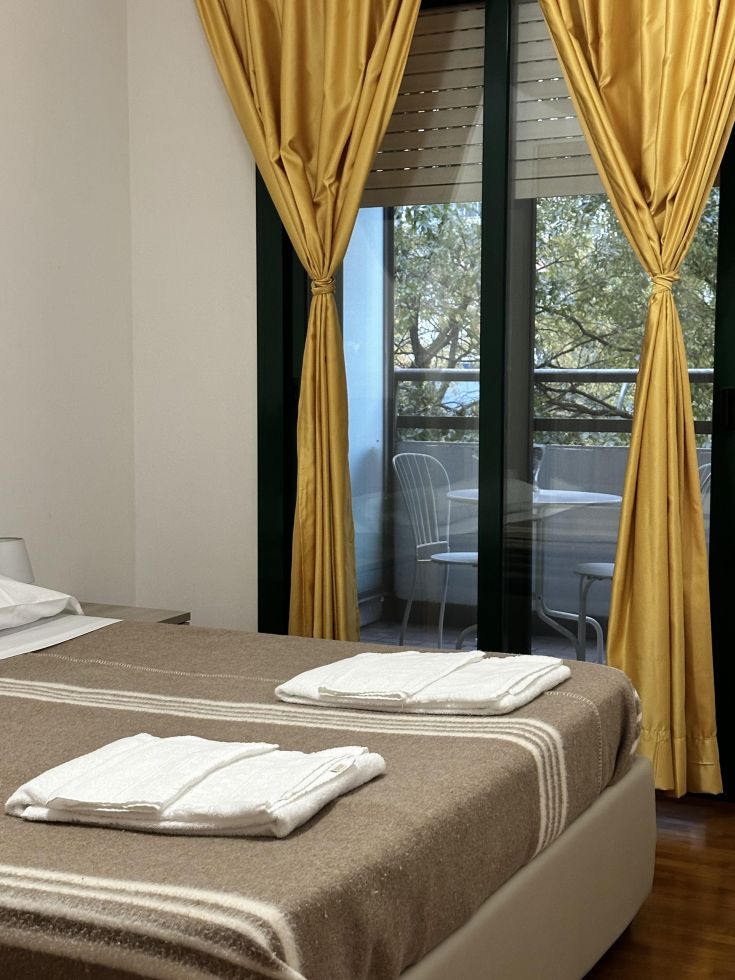 Bright and cozy room with simple furnishings and white tablecloths, ideal for a peaceful stay.