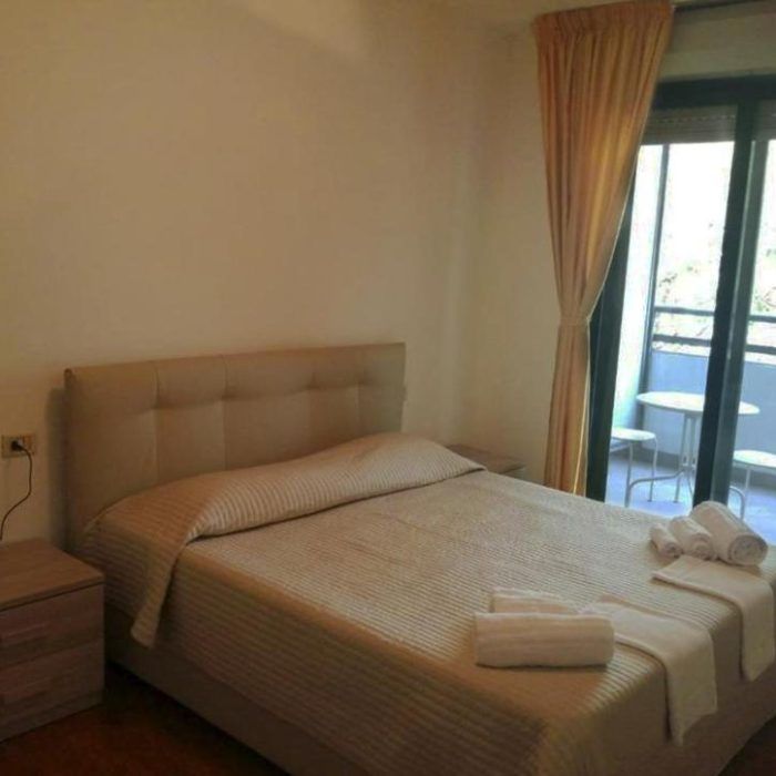 Cozy and well-lit room featuring a double bed and access to a balcony.