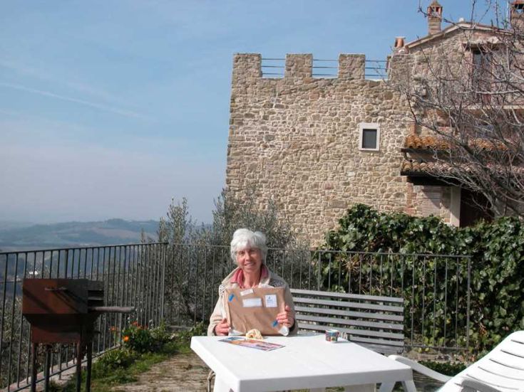 Ein friedlicher Moment im Freien, mit einem historischen Gebäude im Hintergrund und der umbrischen Landschaft.