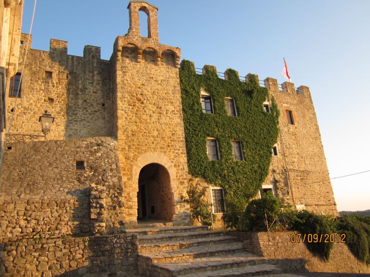 Ein mit Efeu bewachsenes Steingebäude in einer ruhigen historischen Umgebung.