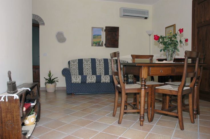 Soggiorno luminoso con arredi in legno, offre un'atmosfera tranquilla e confortevole per momenti di relax.