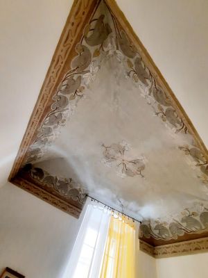 Plafond décoré avec des fresques florales montrant des détails d'une décoration historique.