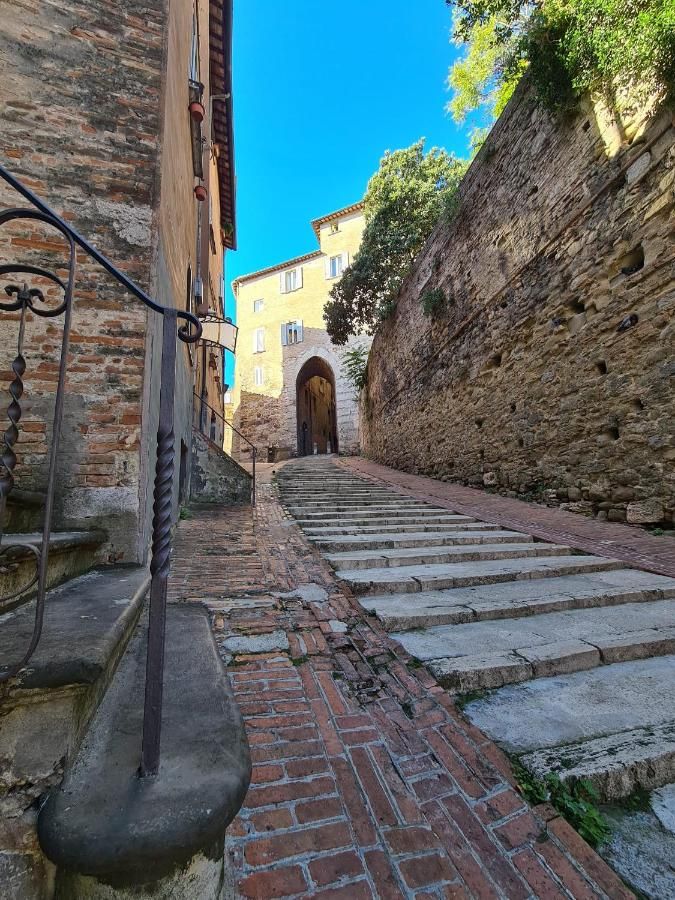Une ruelle dans le centre d'une ville ombrienne, avec des escaliers en brique et une atmosphère pittoresque.