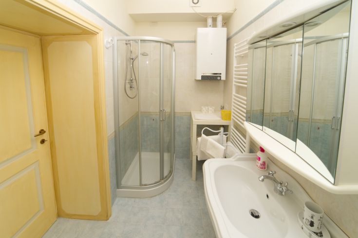 Modern bathroom with shower and sink, featuring simple and practical decor.