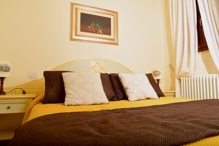 Spacious and well-lit room with comfortable beds and simple details, perfect for relaxation moments.