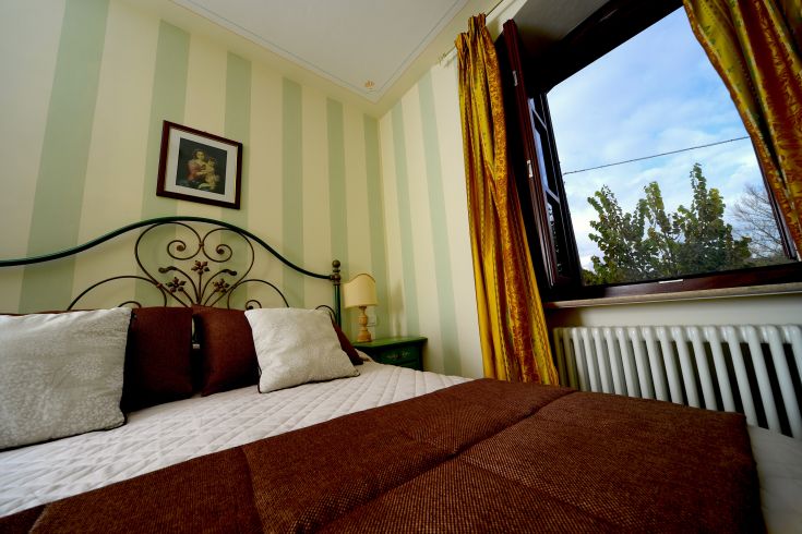 Cozy room with garden views, featuring simple and comfortable furnishings for a pleasant stay.
