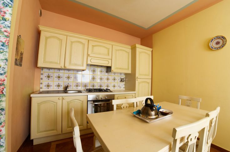 Spacious and well-lit kitchen with a table and dishes, perfect for moments of togetherness.