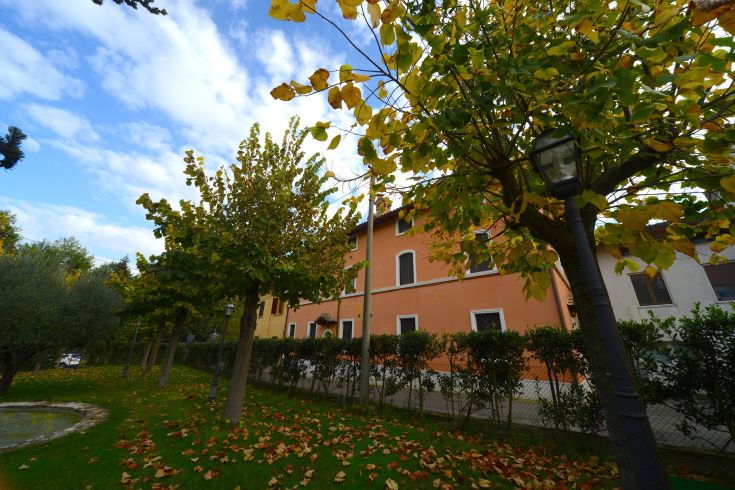 Scene of the Luncinaia Residence, surrounded by greenery with trees and a well-maintained garden.