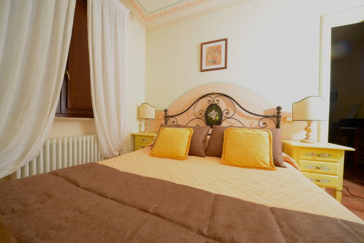 Intimate space with a double bed, simply furnished in warm tones. Relaxing and cozy atmosphere.
