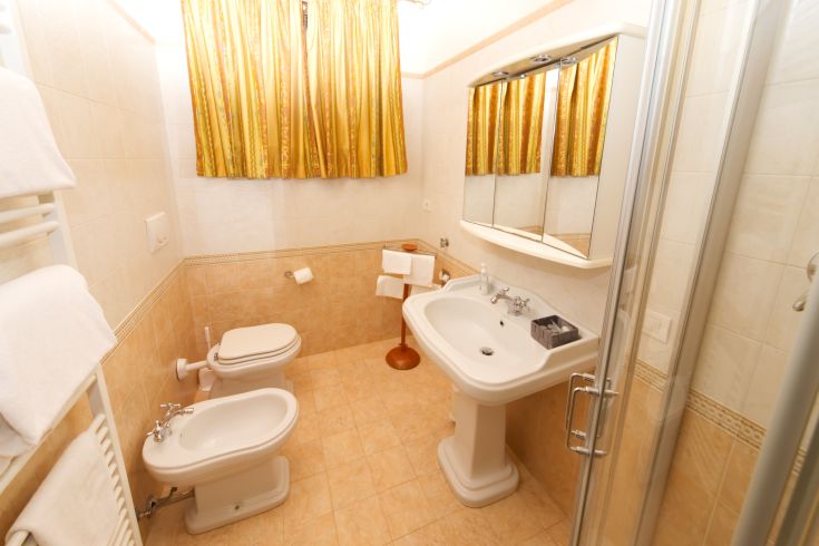 Well-kept bathroom with modern finishes and light curtains, located in a cozy holiday residence.
