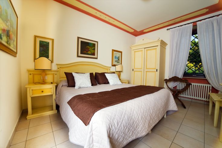 A simple room with a double bed and light wood furniture, perfect for a quiet stay.