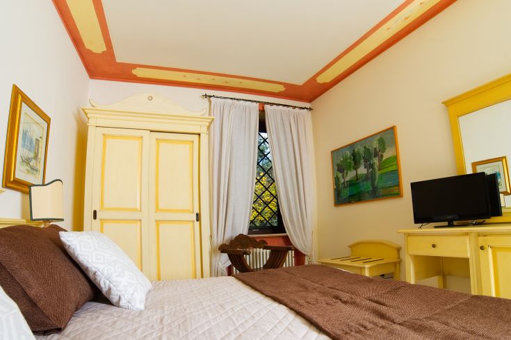 Cozy room with simple furnishings and a view of a green area.