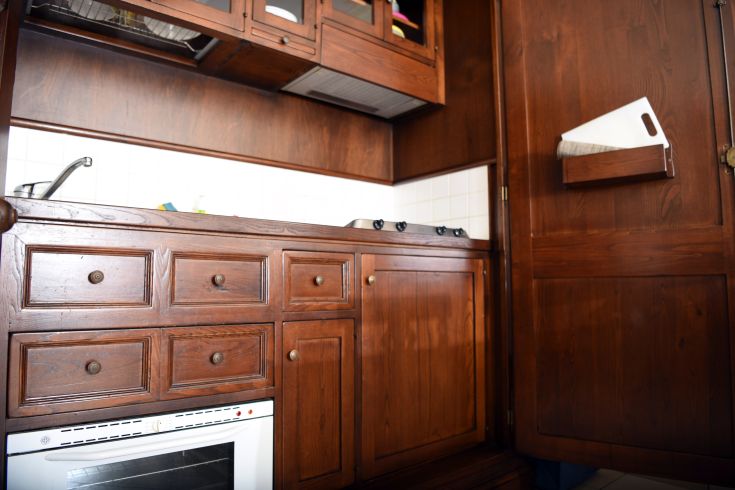 Light wooden kitchen with spacious cabinets and a cooking surface, ideal for a holiday residence.